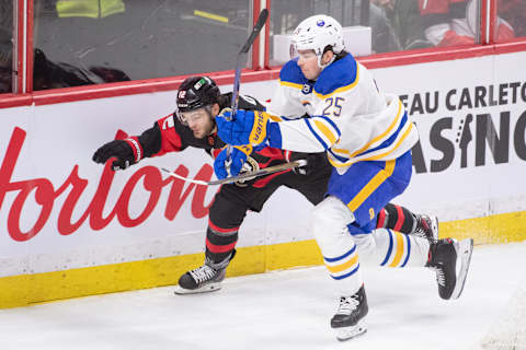 Jan 1,, 2023; Ottawa, Ontario, CAN; Ottawa Senators right wing Alex DeBrincat (12) and Buffalo Sabres defenseman Owen Power (25) battle in the third period at the Canadian Tire Centre. Mandatory Credit: Marc DesRosiers-USA TODAY Sports