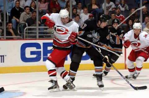 WASHINGTON – JANUARY 21: Bryan Muir #47 of the Washington Capitals tries to control the puck Andrew Ladd #16 of the Carolina Hurricanes on January 21, 2006, at MCI Center in Washington D.C. (Photo by Mitchell Layton/Getty Images)