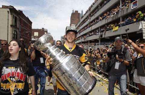 Jun 15, 2016; Pittsburgh, PA, USA; Fans look on from a parking garage as Pittsburgh Penguins defenseman Kris Letang (58) carries the cup during the Stanley Cup championship parade and celebration in downtown Pittsburgh. Mandatory Credit: Charles LeClaire-USA TODAY Sports