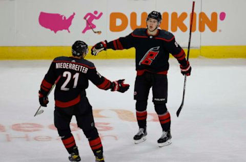 RALEIGH, NORTH CAROLINA – MARCH 04: Nino Niederreiter #21 of the Carolina Hurricanes celebrates with teammate Martin Necas #88 following an empty-net goal by Niederreiter during the third period of their game against the Detroit Red Wings at PNC Arena on March 04, 2021, in Raleigh, North Carolina. (Photo by Jared C. Tilton/Getty Images)