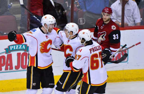 Dec 8, 2016; Glendale, AZ, USA; Calgary Flames defenseman Dougie Hamilton (27) celebrates with center Mikael Backlund (11) and right wing Michael Frolik (67) after scoring a goal in overtime to defeat the Arizona Coyotes 2-1 at Gila River Arena. Mandatory Credit: Matt Kartozian-USA TODAY Sports