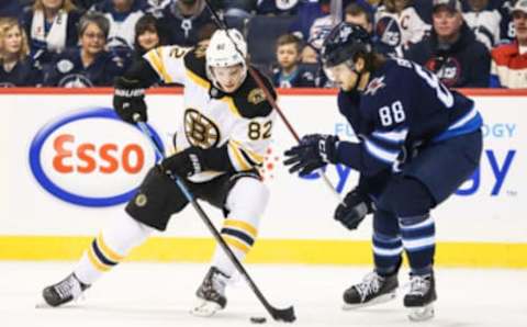 Mar 14, 2019; Winnipeg, Manitoba, CAN; Boston Bruin forward Trent Frederic (82) is defended by Winnipeg Jets defenseman Nathan Beaulieu (88) during the first period at Bell MTS Place. Mandatory Credit: Terrence Lee-USA TODAY Sports