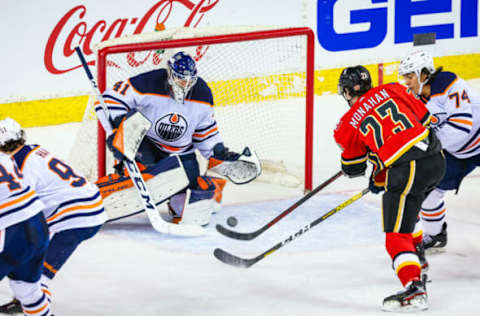 Mar 17, 2021; Calgary, Alberta, CAN; Edmonton Oilers goaltender Mike Smith (41) makes a save as Calgary Flames center Sean Monahan (23) tries to score during the third period at Scotiabank Saddledome. Mandatory Credit: Sergei Belski-USA TODAY Sports