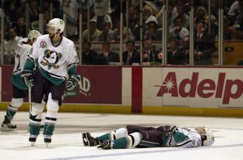 ANAHEIM, CA: Paul Kariya #9 of the Anaheim Mighty Ducks lies on the ice after being hit by Scott Stevens #4 of the New Jersey Devils during the second period during Game Six of the 2003 NHL Stanley Cup Finals on June 7, 2003. (Photo by Brian Bahr/Getty Images/NHLI)