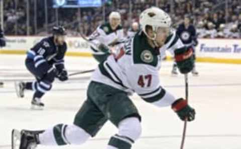 Sep 29, 2016; Winnipeg, Manitoba, CAN; Minnesota Wild forward Christoph Bertschy (47) shoots the puck against Winnipeg Jets goalie Connor Hellebuyck (not pictured) during the first period during a preseason hockey game at MTS Centre. Mandatory Credit: Bruce Fedyck-USA TODAY Sports