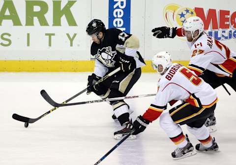 Mar 5, 2016; Pittsburgh, PA, USA; Pittsburgh Penguins right wing Bryan Rust (17) skates with the puck as Calgary Flames defenseman Mark Giordano (5) and defenseman Dougie Hamilton (27) chase during the second period at the CONSOL Energy Center. Mandatory Credit: Charles LeClaire-USA TODAY Sports