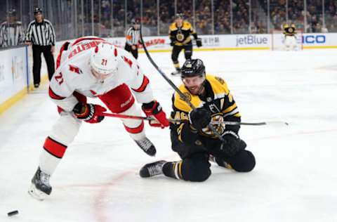 BOSTON, MASSACHUSETTS – DECEMBER 03: Nino Niederreiter #21 of the Carolina Hurricanes shields the puck from David Krejci #46 of the Boston Bruins after he fell on the ice during the third period at TD Garden on December 03, 2019 in Boston, Massachusetts. The Bruins defeat the Hurricanes 2-0. (Photo by Maddie Meyer/Getty Images)