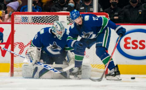 Nov 19, 2021; Vancouver, British Columbia, CAN; Vancouver Canucks goalie Thatcher Demko (35) looks on as defenseman Travis Hamonic (27) blocks a shot against the Winnipeg Jets in the third period at Rogers Arena. Canucks won 3-2. Mandatory Credit: Bob Frid-USA TODAY Sports