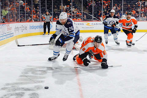 Travis Sanheim tussles with Blake Wheeler for a lose puck near the Flyers’ net. (Photo by Tim Nwachukwu/Getty Images)