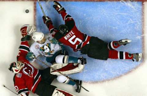 The Mighty Ducks Paul Kariya goes down in between New Jersey’s Martin Brodeur, left and Colin White in the second period of game six of the Stanley Cup Finals. (Photo by Allen J. Schaben/Los Angeles Times via Getty Images)