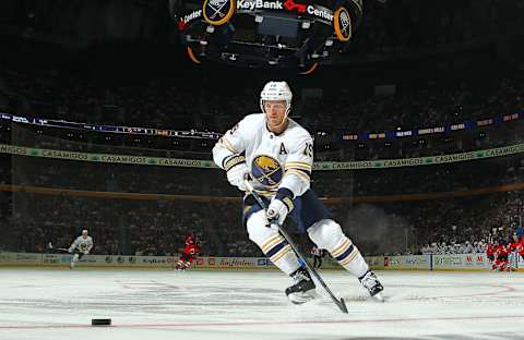 BUFFALO, NY – OCTOBER 5: Jake McCabe #19 of the Buffalo Sabres looks to control the puck during an NHL game against the New Jersey Devils on October 5, 2019 at KeyBank Center in Buffalo, New York. Buffalo won, 7-2. (Photo by Bill Wippert/NHLI via Getty Images)