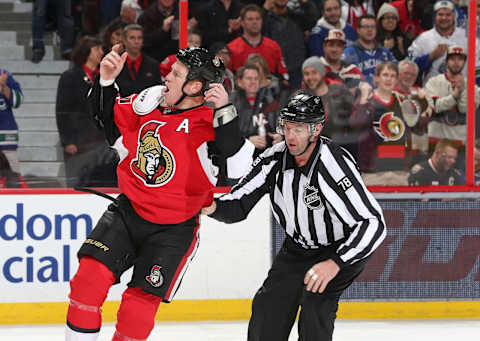 OTTAWA, ON – DECEMBER 7: Linesman Brian Mach #78 steers Chris Neil #25 of the Ottawa Senators to the penalty box as he tries to get the fans going following a fight in the second period against the Vancouver Canucks during an NHL game at Canadian Tire Centre on December 7, 2014 in Ottawa, Ontario, Canada. (Photo by Jana Chytilova/Freestyle Photography/Getty Images)