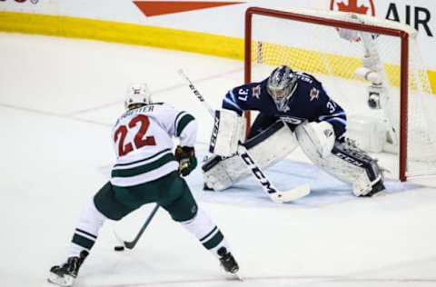 WINNIPEG, MB April 20: Winnipeg Jets goalie Connor Hellebuyck (37) stops Minnesota Wild forward Nino Niederreiter (22) during the Stanley Cup Playoffs First Round Game 5 between the Winnipeg Jets and the Minnesota Wild on April 20, 2018 at the Bell MTS Place in Winnipeg MB. (Photo by Terrence Lee/Icon Sportswire via Getty Images)