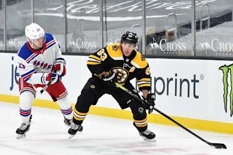 Mar 11, 2021; Boston, Massachusetts, USA; Boston Bruins center Brad Marchand (63) controls the puck against New York Rangers defenseman Adam Fox (23) during the third period at TD Garden. Mandatory Credit: Bob DeChiara-USA TODAY Sports