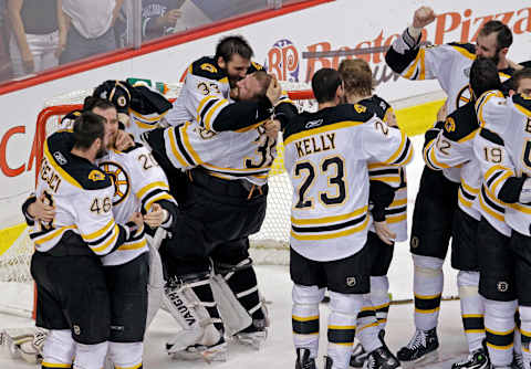 VANCOUVER – JUNE 15: Bruins goalie Tim Thomas hoists teammate Patrice Bergeron at left as the Bruins celebrate their victory. The Boston Bruins visited the Vancouver Canucks for Game Seven of the Stanley Cup Finals at the Rogers Arena. (Photo by Jim Davis/The Boston Globe via Getty Images)