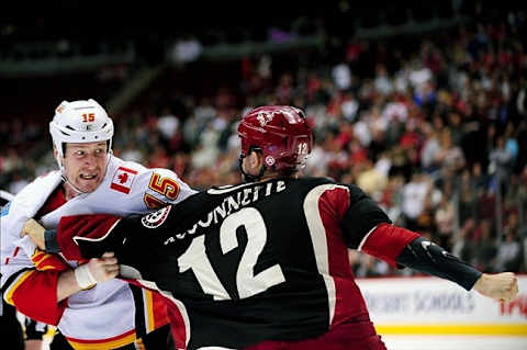 Calgary Flames right wing Tim Jackman gets ready to eat a right hand from Phoenix Coyotes left wing Paul Bissonnette (12) winds up to throw a punch during the second period at Jobing.com Arena. Mandatory Credit: Matt Kartozian-US PRESSWIRE