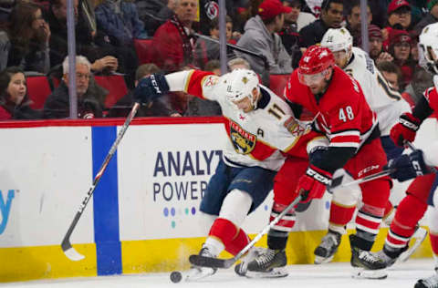 Dec 21, 2019; Raleigh, North Carolina, USA; Florida Panthers left wing Jonathan Huberdeau (11) and Carolina Hurricanes left wing Jordan Martinook (48) battle over the puck during the second period at PNC Arena. Mandatory Credit: James Guillory-USA TODAY Sports