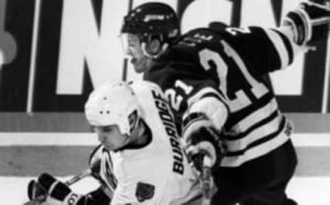 BOSTON – APRIL 3: Boston Bruins player Randy Burridge, left, and Hartford Whalers player Sylvain Cote, right, collide during a division semi-final game at the Boston Garden in Boston on April 3, 1991. (Photo by Pat Greenhouse/The Boston Globe via Getty Images)