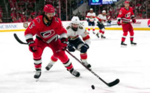 May 20, 2023; Raleigh, North Carolina, USA; Carolina Hurricanes defenseman Jalen “Chat-man-du” Chatfield (5) battles for the puck with Florida Panthers center Colin White (6) in game two of the Eastern Conference Finals of the 2023 Stanley Cup Playoffs at PNC Arena. Mandatory Credit: James Guillory-USA TODAY Sports