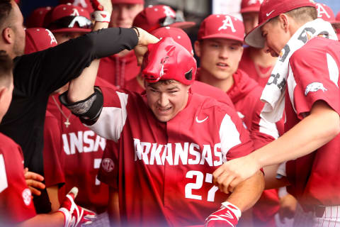 GAINESVILLE, FL – MARCH 25: his teammates congratulate Evan Lee (27) of Arkansas in the dugout as Lee is presented with a Razorback hat during the college baseball game between the Arkansas Razorbacks and the Florida Gators on March 25, 2018, at Alfred A. McKethan Stadium in Gainesville, Florida. (Photo by Cliff Welch/Icon Sportswire via Getty Images)