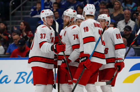 TAMPA, FL – NOVEMBER 30: Carolina Hurricanes defenseman Jaccob Slavin (74) is congratulated by teammates Carolina Hurricanes right wing Andrei Svechnikov (37), Carolina Hurricanes defenseman Dougie Hamilton (19), Carolina Hurricanes left wing Teuvo Teravainen (86) and Carolina Hurricanes right wing Sebastian Aho (20) after scoring a goal in the 1st period of the NHL game between the Carolina Hurricanes and Tampa Bay Lightning on November 30, 2019 at Amalie Arena in Tampa, FL. (Photo by Mark LoMoglio/Icon Sportswire via Getty Images)