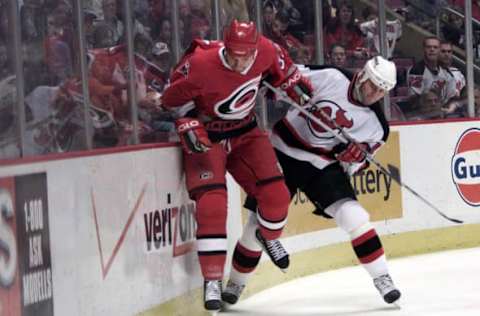 15 Apr 2001: Dave Karpa #33 of the Carolina Hurricanes collides with John Madden #11 of the New Jersey Devils during Sunday’s first round playoff game at Continental Airlines Arena at the Meadowlands in East Rutherford, New Jersey. The Devils defeated the Hurricanes with a final score of 2-0. Digital Image. Mandatory Credit: Jamie Squire/ALLSPORT