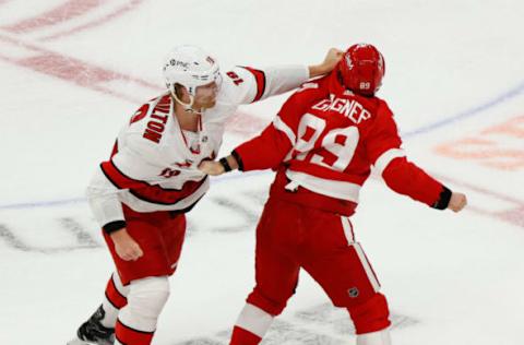 Jan 14, 2021; Detroit, Michigan, USA; Detroit Red Wings center Sam Gagner (89) and Carolina Hurricanes defenseman Dougie Hamilton (19) fight in the second period at Little Caesars Arena. Mandatory Credit: Rick Osentoski-USA TODAY Sports