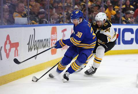 Mar 19, 2023; Buffalo, New York, USA; Buffalo Sabres defenseman Kale Clague (38) tries to clear the puck as Boston Bruins left wing Jake DeBrusk (74) defends during the first period at KeyBank Center. Mandatory Credit: Timothy T. Ludwig-USA TODAY Sports