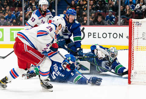 VANCOUVER, BC – NOVEMBER 2: Tucker Poolman #5 of the Vancouver Canucks deflects the shot of Chris Kreider #20 of the New York Rangers wide of the net as goalie Thatcher Demko #35 and J.T. Miller #9 scramble to defend during the third period on November 2, 2021 at Rogers Arena in Vancouver, British Columbia, Canada. (Photo by Rich Lam/Getty Images)