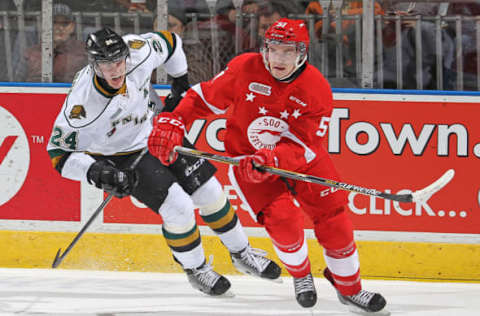 LONDON, ON – DECEMBER 5: Kyle Jenkins #51 of the Sault Ste. Marie Greyhounds skates away from a checking Michael McCarron #24 of the London Knights in an OHL game at Budweiser Gardens on December 5, 2014 in London, Ontario, Canada. The Greyhounds defeated the Knights 4-0. (Photo by Claus Andersen/Getty Images)