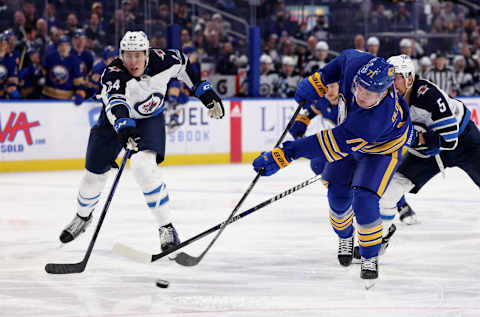 Mar 30, 2022; Buffalo, New York, USA; Winnipeg Jets defenseman Logan Stanley (64) tries to block a shot by Buffalo Sabres left wing Victor Olofsson (71) during the second period at KeyBank Center. Mandatory Credit: Timothy T. Ludwig-USA TODAY Sports