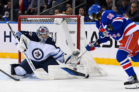 Apr 19, 2022; New York, New York, USA; Winnipeg Jets goaltender Eric Comrie (1) makes a save on a shot from New York Rangers left wing Artemi Panarin (10) during the first period at Madison Square Garden. Mandatory Credit: Dennis Schneidler-USA TODAY Sports