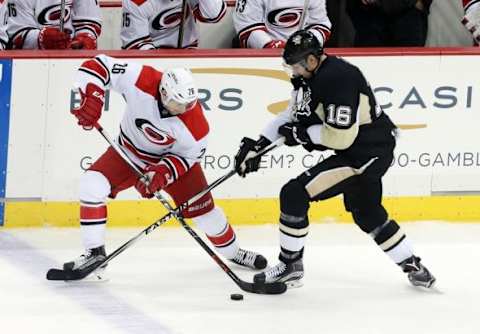 Jan 17, 2016; Pittsburgh, PA, USA; Carolina Hurricanes defenseman John-Michael Liles (26) and Pittsburgh Penguins right wing Eric Fehr (16) fight to control the puck during the second period at the CONSOL Energy Center. The Penguins won 5-0. Mandatory Credit: Charles LeClaire-USA TODAY Sports