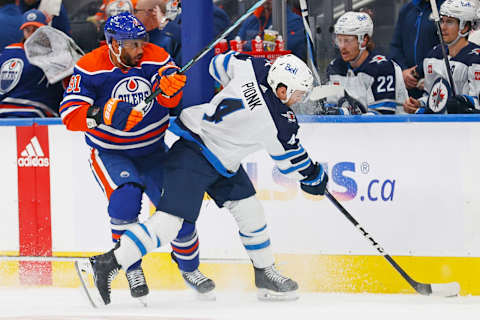 Oct 21, 2023; Edmonton, Alberta, CAN; Edmonton Oilers forward Evander Kane (91) tries to knock Winnipeg jets defensemen Declan Chisholm (45) off the puck during the first period at Rogers Place. Mandatory Credit: Perry Nelson-USA TODAY Sports