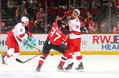 NEWARK, NJ – JANUARY 22: Pavel Zacha #37 of the New Jersey Devils collides with Vincent Trocheck #16 of the Carolina Hurricanes during the National Hockey League game between the New Jersey Devils and the Carolina Hurricanes on January 22, 2022, at the Prudential Center in Newark, New Jersey. (Photo by Rich Graessle/Getty Images)