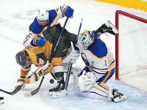 Dec 19, 2022; Las Vegas, Nevada, USA; Buffalo Sabres defenseman Ilya Lyubushkin (46) checks Vegas Golden Knights left wing William Carrier (28) as Sabres goaltender Ukko-Pekka Luukkonen (1) makes a save during the third period at T-Mobile Arena. Mandatory Credit: Stephen R. Sylvanie-USA TODAY Sports