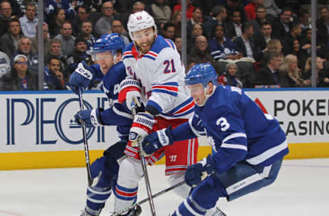 TORONTO, CANADA – JANUARY 25: Barclay Goodrow #21 of the New York Rangers tries to squeeze between Morgan Rielly #44 and Justin Holl #3 of the Toronto Maple Leafs during an NHL game at Scotiabank Arena on January 25, 2023, in Toronto, Ontario, Canada. The Maple Leafs defeated the Rangers 3-2 in overtime. (Photo by Claus Andersen/Getty Images)