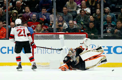 ANAHEIM, CALIFORNIA – DECEMBER 09: John Gibson #36 of the Anaheim Ducks slides for the save on a shot from Kyle Palmieri #21 of the New Jersey Devils during a shoot out at Honda Center on December 09, 2018 in Anaheim, California. (Photo by Katharine Lotze/Getty Images)