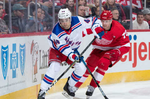 DETROIT, MI – MARCH 07: Neal Pionk #44 of the New York Rangers skates with the puck along the boards followed by Christoffer Ehn #70 of the Detroit Red Wings during an NHL game at Little Caesars Arena on March 7, 2019 in Detroit, Michigan. (Photo by Dave Reginek/NHLI via Getty Images)