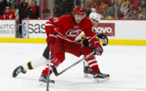 Feb 26, 2016; Raleigh, NC, USA; Carolina Hurricanes forward Victor Rask (49) skates with the puck as Boston Bruins defensemen Zdeno Chara (33) defends during the second period at PNC Arena. Mandatory Credit: James Guillory-USA TODAY Sports