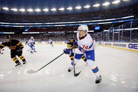 Jan 1, 2016; Foxborough, MA, USA; Montreal Canadiens defenseman Alexei Emelin (74) passes the puck in front of Boston Bruins left wing Matt Beleskey (39) and center Ryan Spooner (51) in the Winter Classic hockey game at Gillette Stadium. Mandatory Credit: Greg M. Cooper-USA TODAY Sports