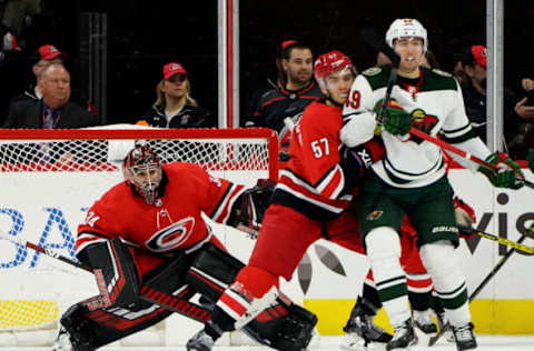 RALEIGH, NC – DECEMBER 07: Petr Mrazek #34 of the Carolina Hurricanes crouches in the crease to protect the net as teammate Trevor van Riemsdyk #57 creates traffic with Victor Rask #49 of the Minnesota Wild during an NHL game on December 7, 2019 at PNC Arena in Raleigh, North Carolina. (Photo by Gregg Forwerck/NHLI via Getty Images)