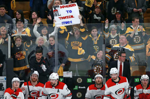 BOSTON – MAY 12: After the Bruins went ahead 3-0, the Carolina Hurricanes bench looks on as a Boston fan in the background hoists a sign reading “Downgraded To Tropical Storm.” The Boston Bruins host the Carolina Hurricanes in Game 2 of the NHL Eastern Conference Finals on May 12, 2019. (Photo by Jim Davis/The Boston Globe via Getty Images)