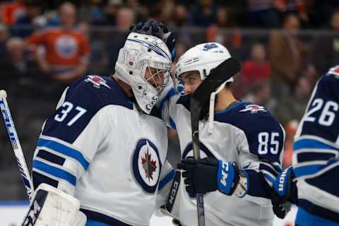 Goaltender Connor Hellebuyck and Mathieu Perreault of the Winnipeg Jets celebrate their victory against the Edmonton Oilers at Rogers Place on March 11, 2020, in Edmonton, Canada.