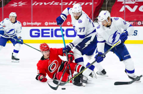 Feb 22, 2021; Raleigh, North Carolina, USA; Carolina Hurricanes center Martin Necas (88) is checked by Tampa Bay Lightning defenseman Victor Hedman (77)and defenseman Jan Rutta (44) during the second period at PNC Arena. Mandatory Credit: James Guillory-USA TODAY Sports