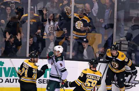 BOSTON – NOVEMBER 6: Minnesota Wild’s Mikko Koivu (9) finds himself in the middle of the celebration, both on the ice and off, after the Bruins’ Tim Schaller (59) scored a late empty net goal to wrap up Boston’s 5-3 victory. The Bruins’ Jordan Szwarz (21, left), and Sean Kuraly (52, right) are also pictured. The Boston Bruins host the Minnesota Wild in a regular season NHL hockey game at TD Garden in Boston on Nov. 6, 2017. (Photo by Jim Davis/The Boston Globe via Getty Images)