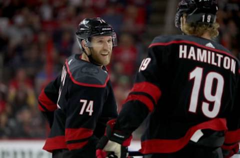 RALEIGH, NC – APRIL 15: Jaccob Slavin #74 of the Carolina Hurricanes chats with teammate Dougie Hamilton #19 before a faceoff in Game Three of the Eastern Conference First Round against the Washington Capitals during the 2019 NHL Stanley Cup Playoffs on April 15, 2019 at PNC Arena in Raleigh, North Carolina. (Photo by Gregg Forwerck/NHLI via Getty Images)