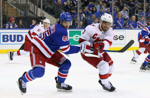 NEW YORK, NEW YORK – MAY 28: Braden Schneider #45 of the New York Rangers checks Max Domi #13 of the Carolina Hurricanes in Game Six of the Second Round of the 2022 Stanley Cup Playoffs at Madison Square Garden on May 28, 2022, in New York City. The Rangers defeated the Hurricanes 5-2. (Photo by Bruce Bennett/Getty Images)