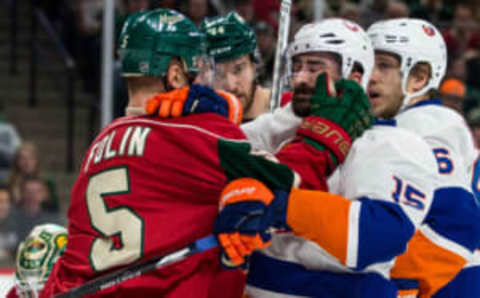 Dec 29, 2016; Saint Paul, MN, USA; Minnesota Wild defenseman Christian Folin (5) grabs New York Islanders forward Cal Clutterbuck (15) after the whistle during the first period at Xcel Energy Center. Mandatory Credit: Brace Hemmelgarn-USA TODAY Sports