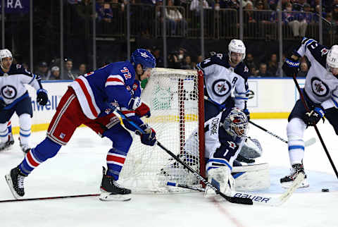 NEW YORK, NEW YORK – APRIL 19: Filip Chytil #72 of the New York Rangers wraps around the net as Eric Comrie #1 of the Winnipeg Jets makes the save during the second period at Madison Square Garden on April 19, 2022 in New York City. (Photo by Elsa/Getty Images)